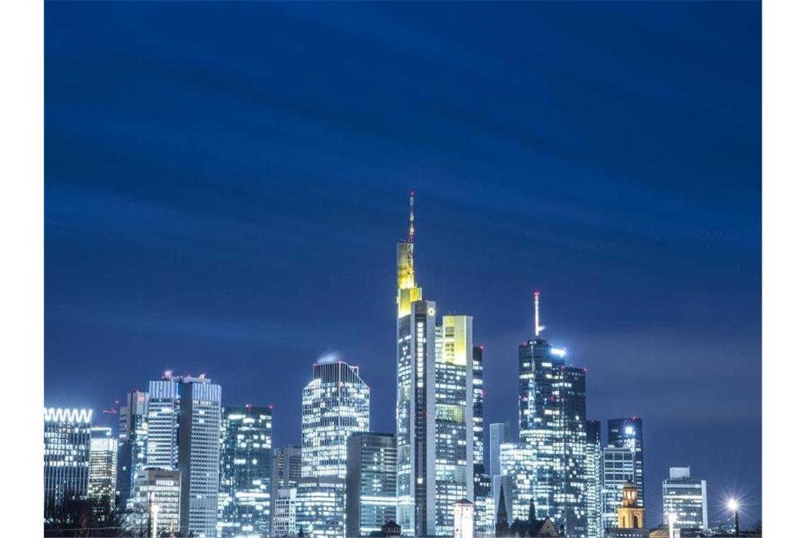 Die Lichter in den Büros der Frankfurter Bankentürme leuchten im letzten Licht des Tages. Foto: Boris Roessler/dpa