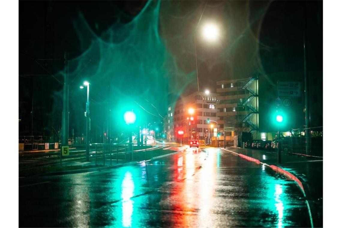 Tauender Schnee, steigende Pegel: Aber keine kritische Lage Die Lichter von Ampeln und Autos werden am frühen Morgen von der regennassen Straße reflektiert. Foto: Christoph Schmidt/dpa