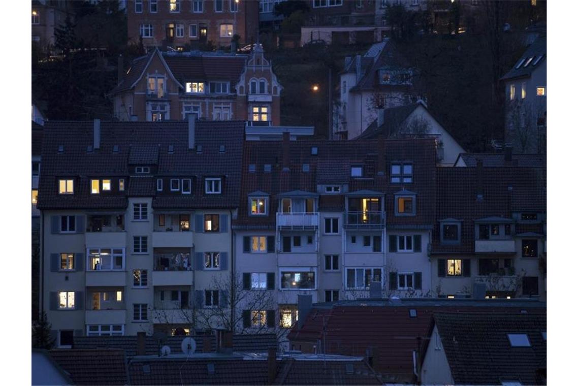 Die Lichter von Wohnhäusern leuchten in der blauen Stunde. Foto: Sebastian Gollnow/dpa/Archiv