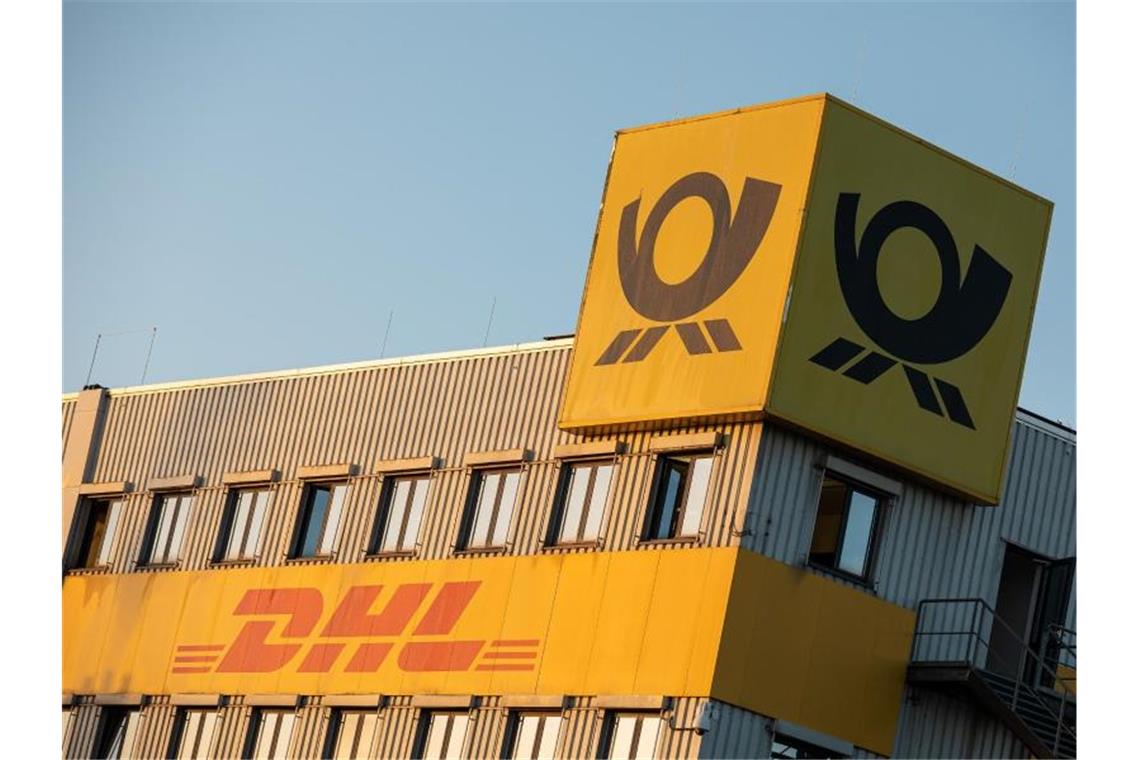 Die Logos der Deutschen Post und von DHL. Foto: Moritz Frankenberg/dpa