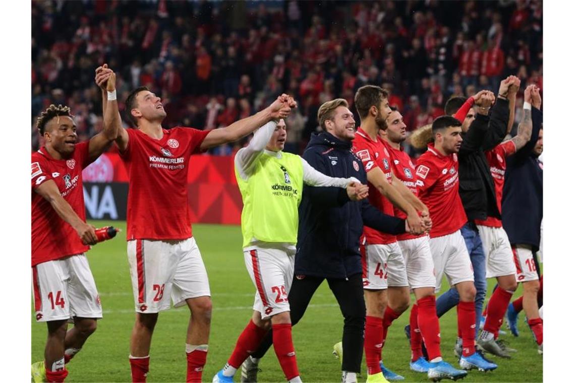 Wieder Handspiel-Debatte: Köln hadert mit dem Schiedsrichter Die Mainzer Spieler lassen sich nach dem 3:1-Sieg gegen den 1. FC Köln von ihren Fans feiern. Foto: Thomas Frey/dpa