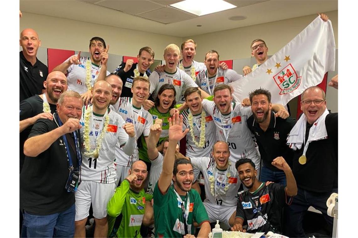 Die Mannschaft des SC Magdeburg jubelt über den Sieg im Finale des IHF Super Globe in Saudi Arabien gegen den FC Barcelona. Foto: -/SC Magdeburg/dpa