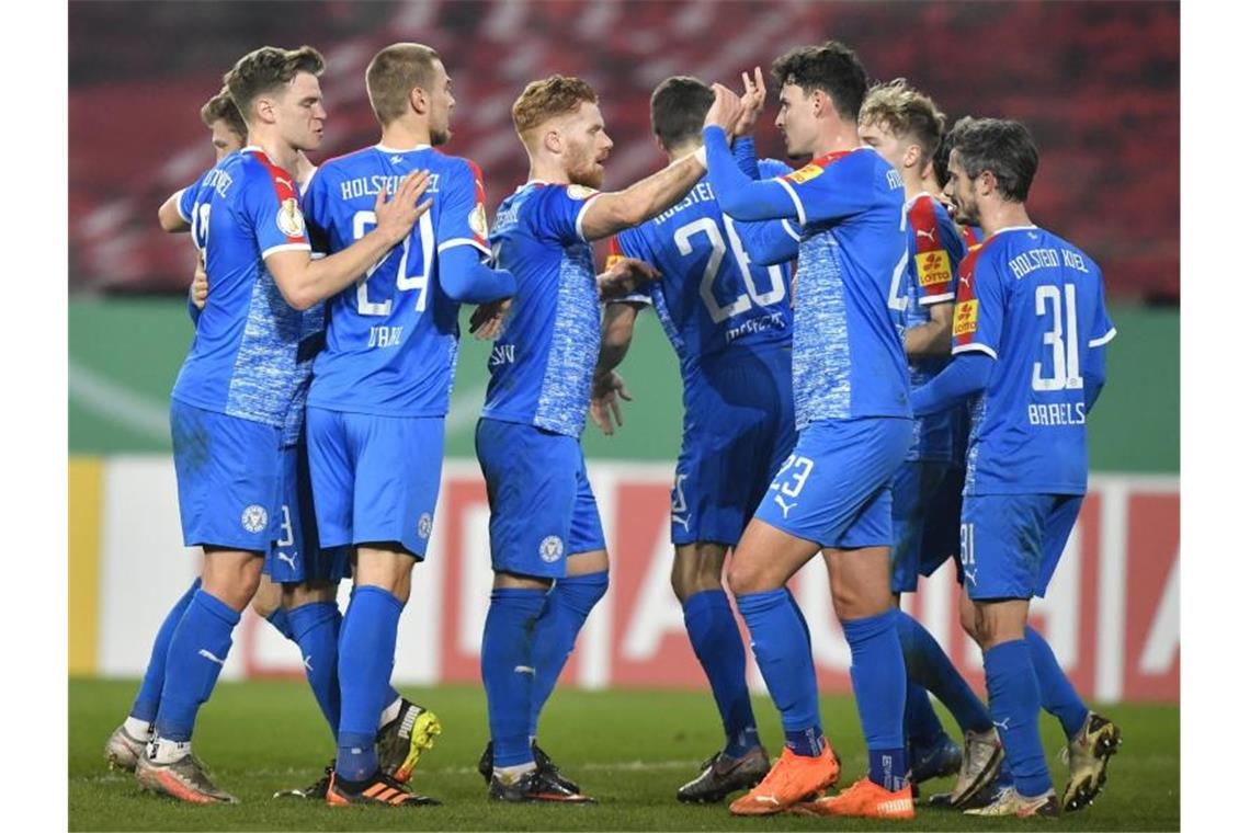 Elfmeter und Doppelschlag: Bayern-Schreck Kiel stoppt Essen Die Mannschaft von Holstein Kiel bejubelt ein Tor gegen Rot-Weiss Essen. Foto: Martin Meissner/AP POOL/dpa