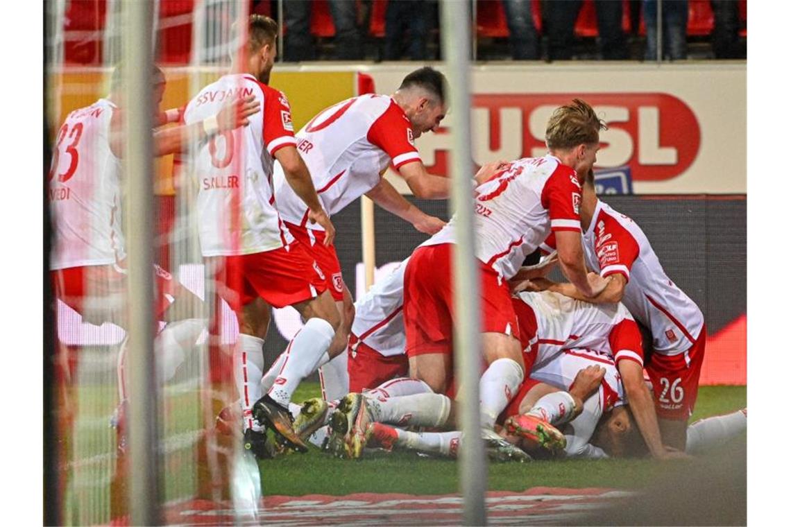 Die Mannschaft von Regensburg jubelt nach dem Treffer zum 3:2 gegen Aue. Foto: Armin Weigel/dpa