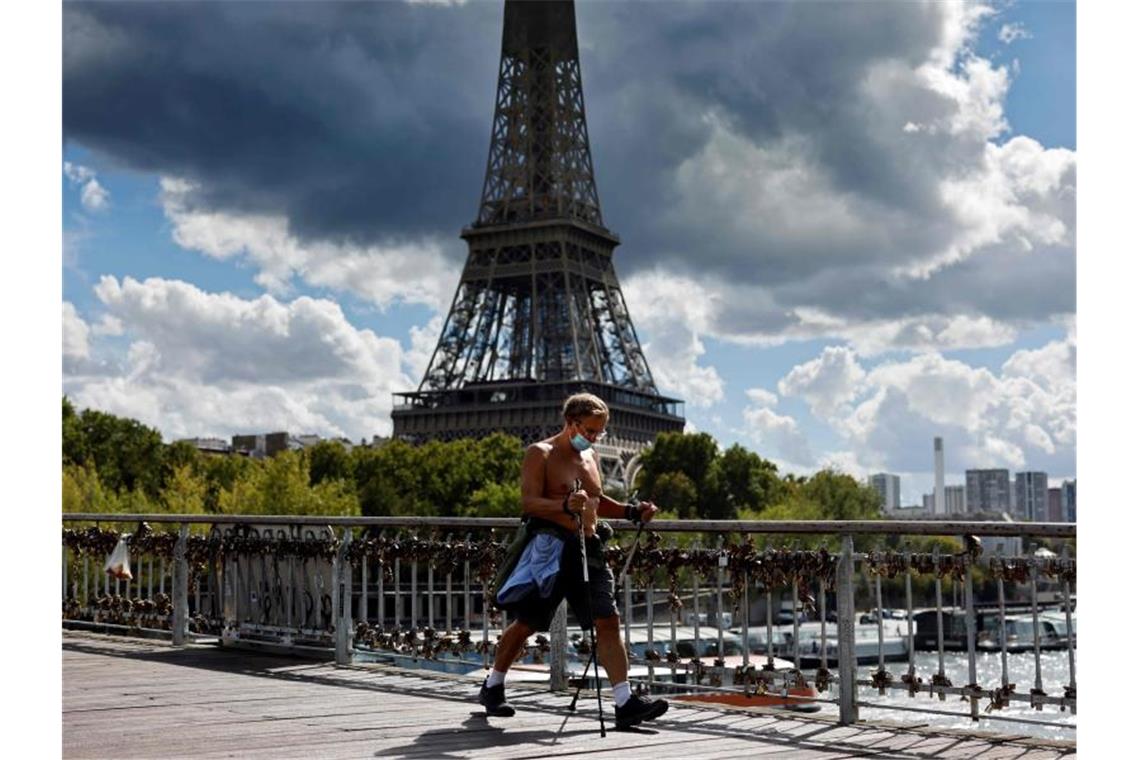 Die Maske ist mittlerweile in ganz Paris Pflicht - doch in Frankreich steigen die Zahlen weiter kräftig an. Foto: Thomas Coex/AFP/dpa