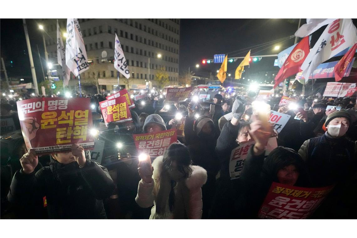 Bericht: Mehrere Minister in Südkorea wollen zurücktreten Die Menge vor dem Parlament protestierte lautstark gegen Yoons Vorgehen.