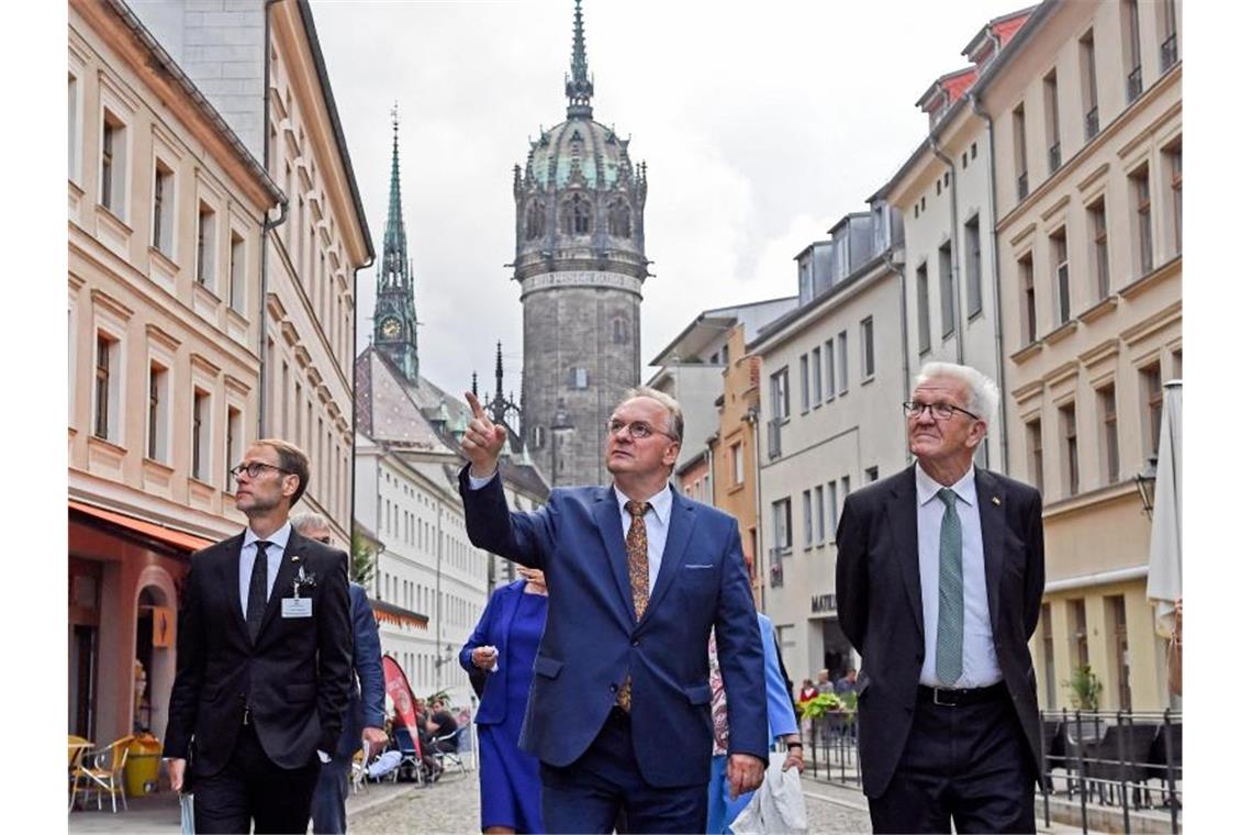 Die Ministerpräsidenten Reiner Haseloff (CDU, M) udn Winfried Kretschmann (Grüne, r) in Wittenberg. Foto: Hendrik Schmidt/dpa-Zentralbild/dpa