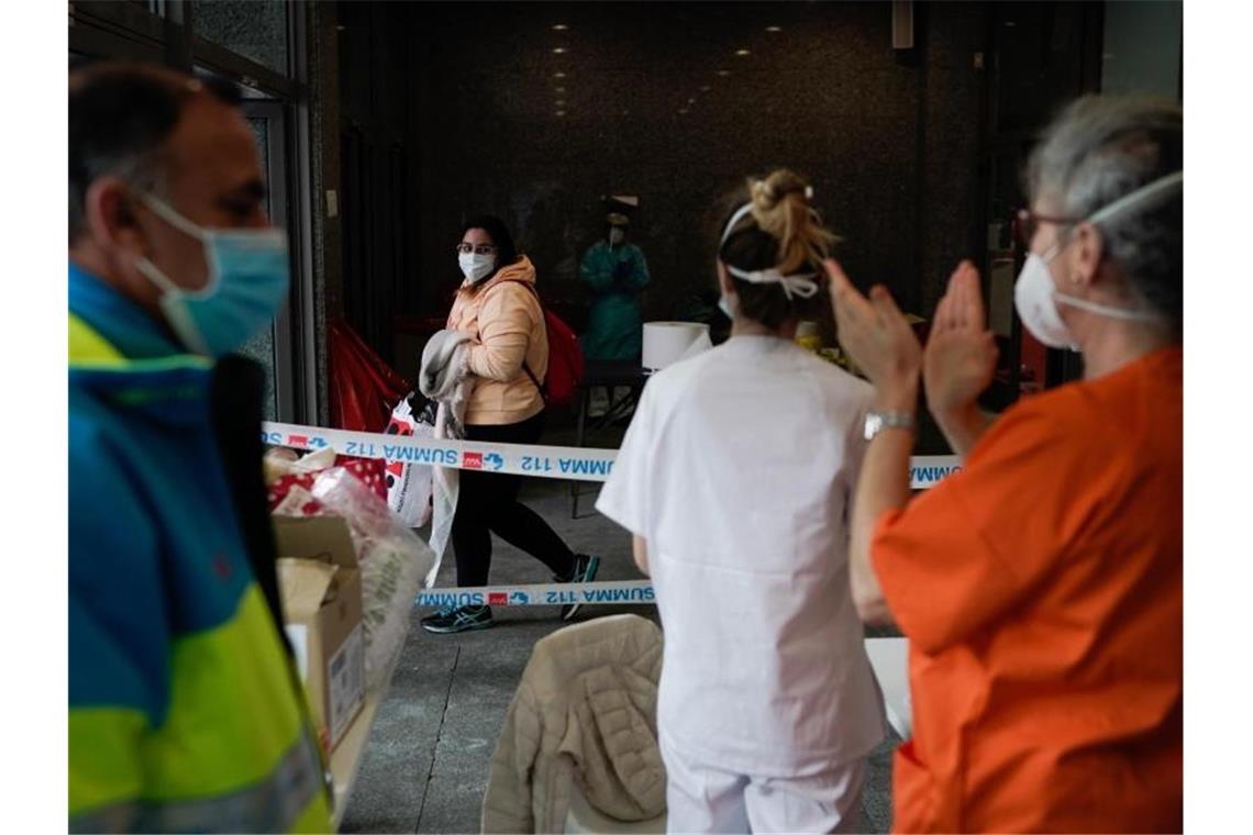 Die Mitarbeiter des auf der Madrider Messe eingerichteten provisorischen Krankenhauses applaudieren einer Patientin, die das Coronavirus überwunden hat. Foto: Comunidad De Madrid/Europa Press/dpa