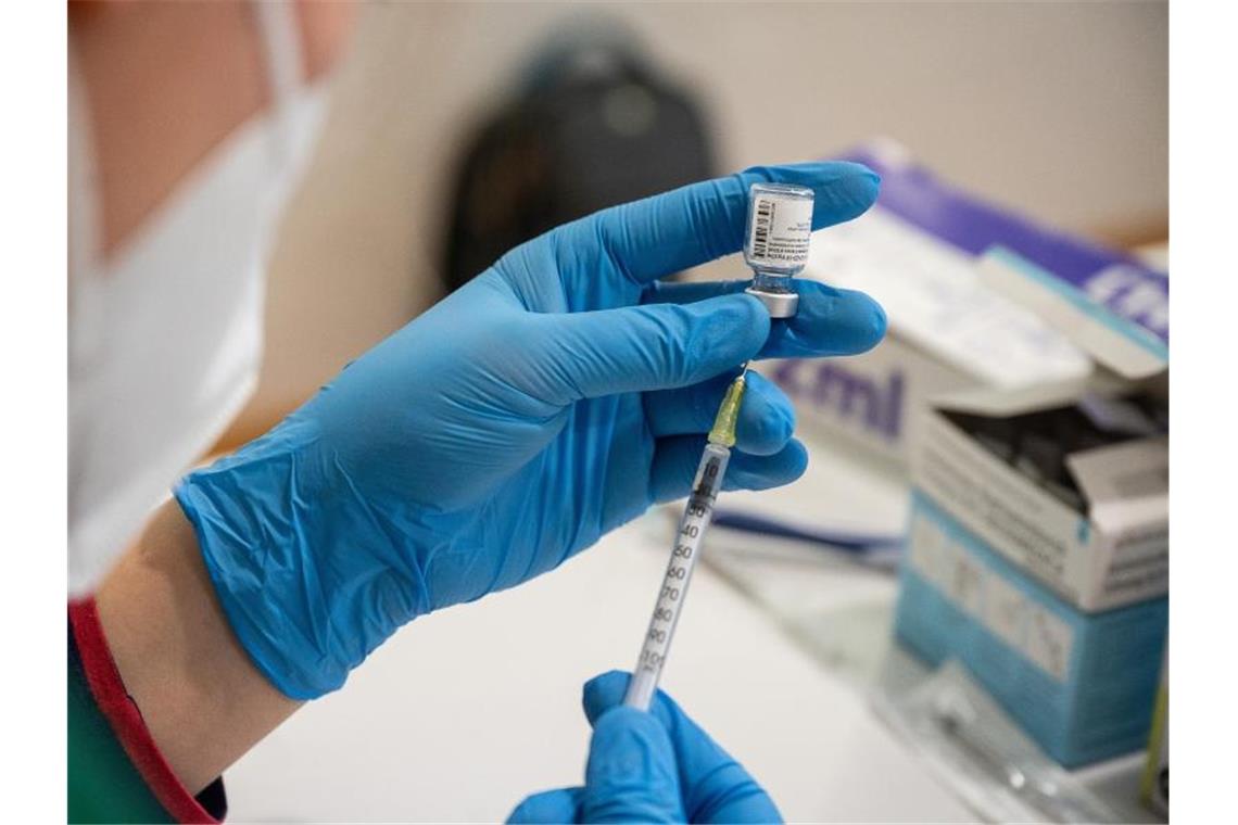 Die Mitarbeiterin eines mobilen Impfteams zieht den Impfstoff von Biontech/Pfizer auf eine Spritze. Foto: Sebastian Gollnow/dpa