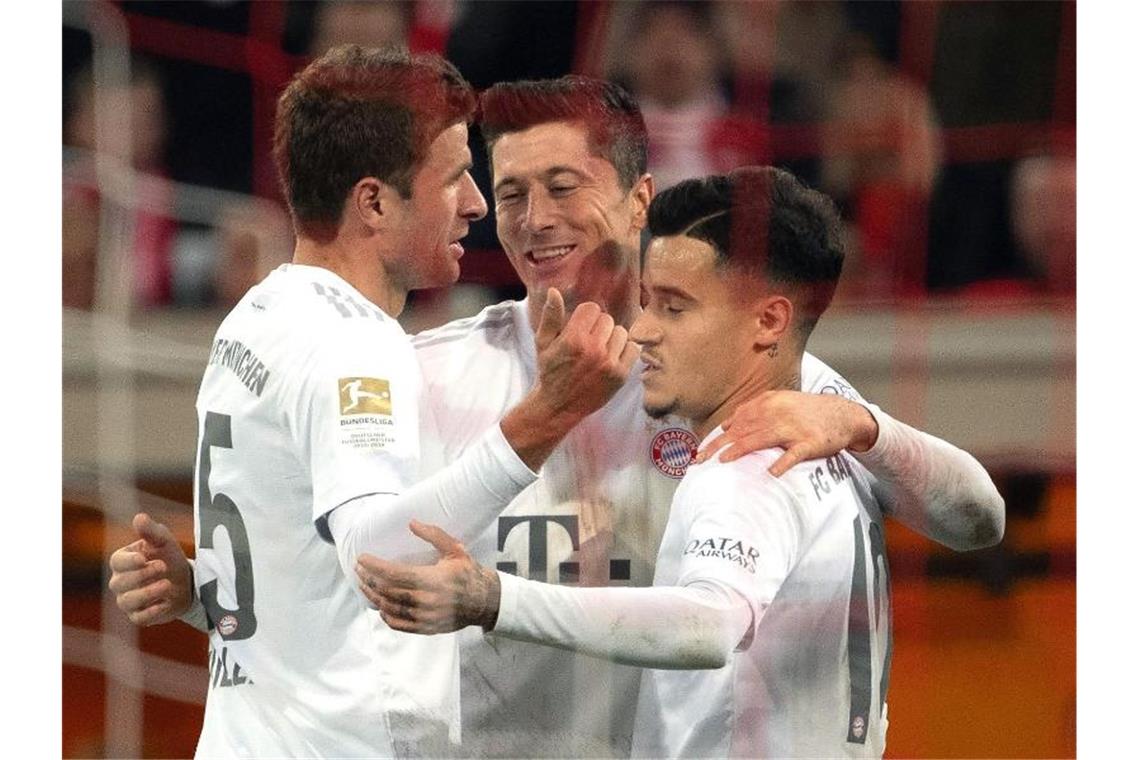 Die Münchner Thomas Müller (l), Philippe Coutinho (r) und Robert Lewandowski feiern das 4:0. Foto: Federico Gambarini/dpa