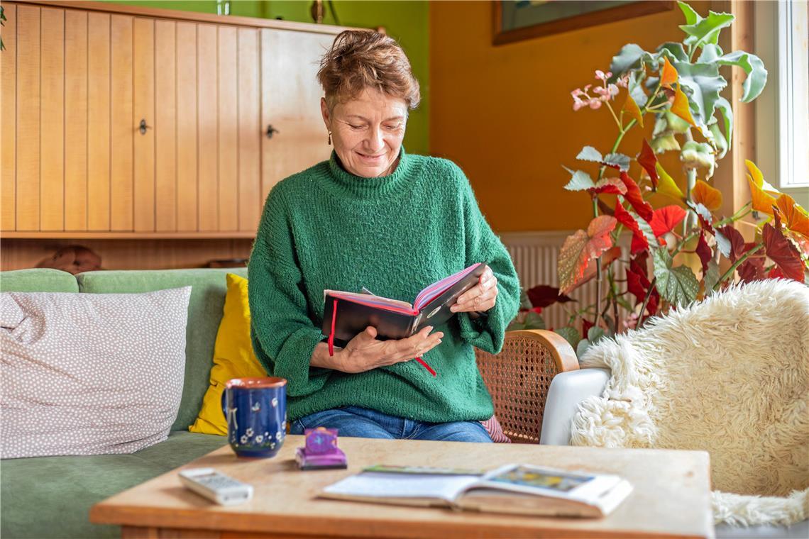 Die Murrhardterin Pia Dahlinger schaut in eines der zwei Bücher, in die sie ihre Pilgergäste hineinschreiben lässt. Viele Menschen schicken ihr auch später noch Postkarten, etwa wenn sie in Santiago angekommen sind. Fotos: Stefan Bossow