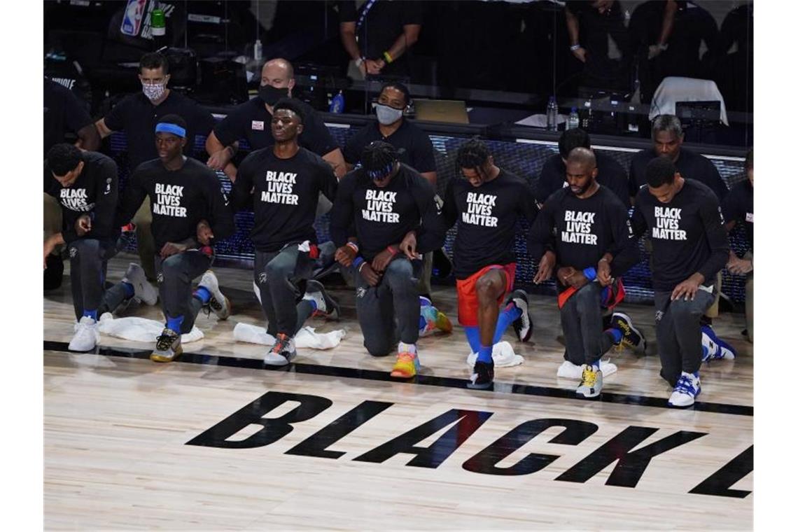 Proteste auch bei Schröder-Start in NBA-Restsaison Die NBA-Profis von Oklahoma City Thunder um Dennis Schröder (2.v.l) während der US-Hymne. Foto: Ashley Landis/Pool AP/dpa