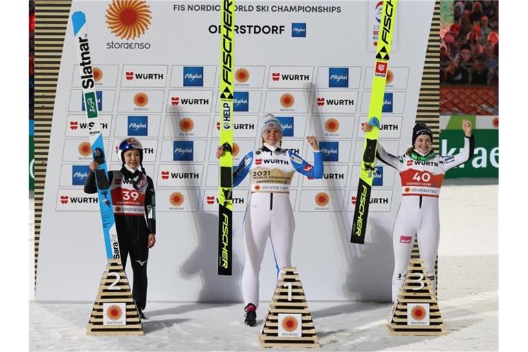 Die Norwegerin Maren Lundby (M) siegte auf der Großschanze vor der Japanerin Sara Takanschi (l) und Nika Kriznar aus Slowenien. Foto: Daniel Karmann/dpa