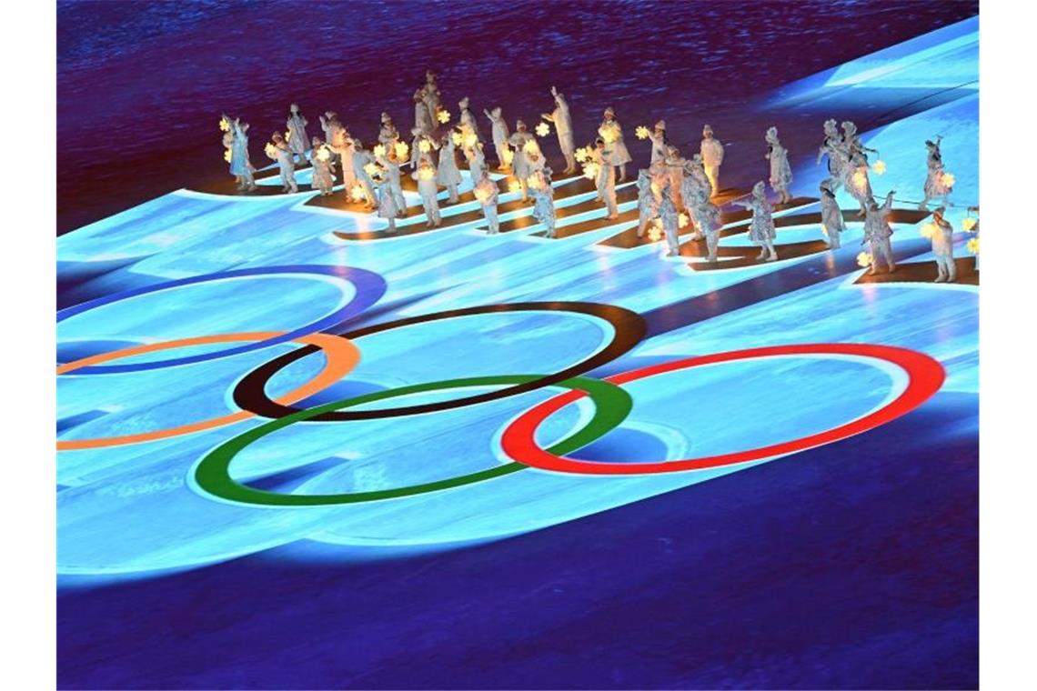 „Außergewöhnliche Spiele“: Olympia in Peking ist Geschichte Die olympischen Ringe erstrahlen während der finalen Zeremonie vor den Artisten. Foto: Peter Kneffel/dpa