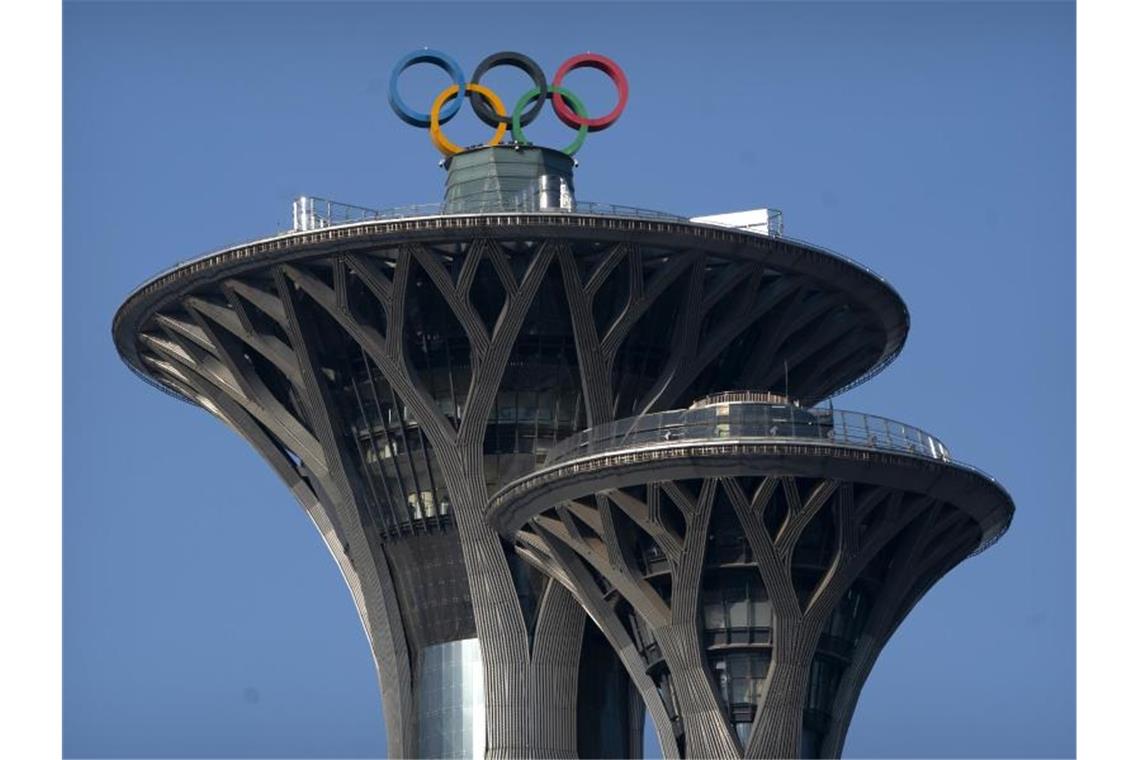 Die olympischen Ringe sind auf der Spitze des Olympiaturms in Peking zu sehen. Foto: Mark Schiefelbein/AP/dpa