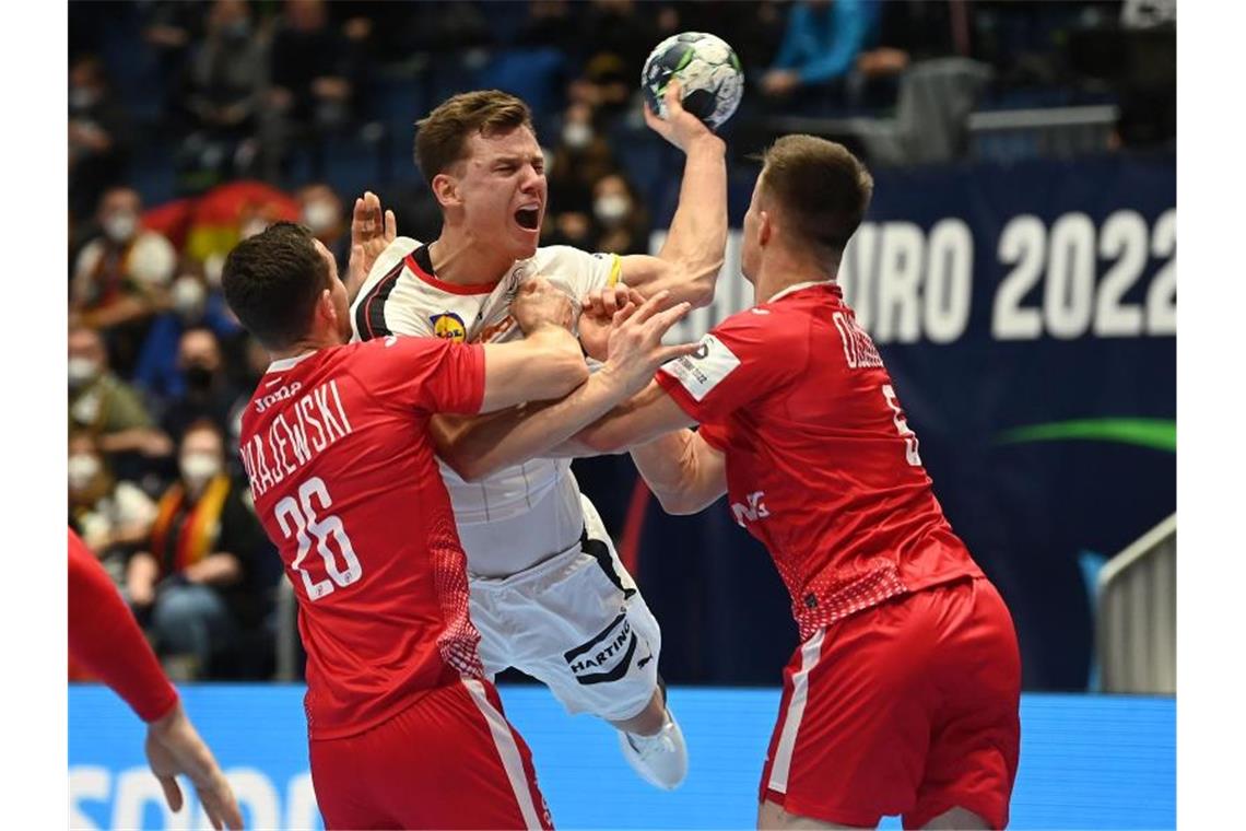 Dezimiertes DHB-Team trotzt Corona: Sieg gegen Polen Die Polen Przemyslaw Krajewski (l) und Michal Olejniczak (r) wehren einen Angriff von Christoph Steinert ab. Foto: Marijan Murat/dpa