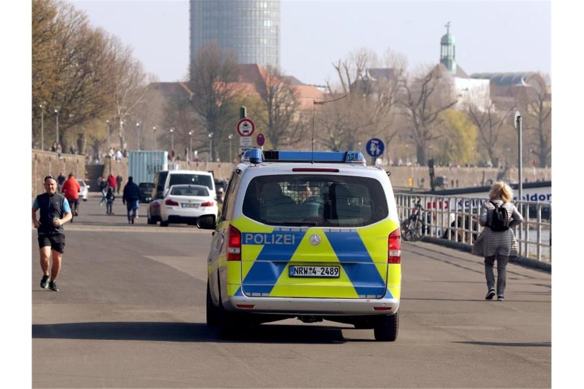 Die Polizei kontrolliert an der Rheinufer Promenade in Düsseldorf die Einhaltung der Vorsichtsmaßnahmen. Foto: David Young/dpa