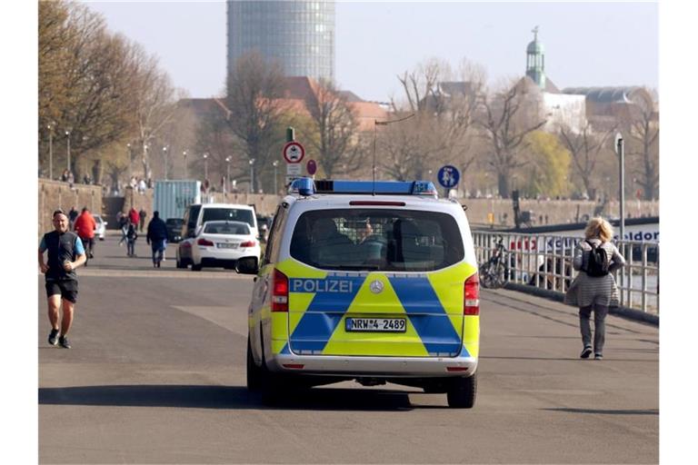 Die Polizei kontrolliert an der Rheinufer Promenade in Düsseldorf die Einhaltung der Vorsichtsmaßnahmen. Foto: David Young/dpa