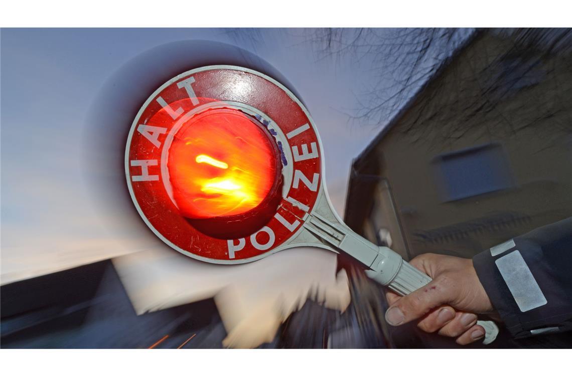 Die Polizei kontrolliert ein Auto. (Symbolbild).