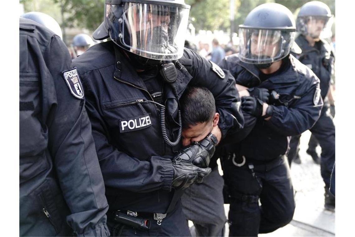Die Polizei nimmt Vegan-Koch Attila Hildmann fest. Zuvor war es vor der russischen Botschaft zu Auseinandersetzungen der Demonstranten mit den Einsatzkräften gekommen. Foto: Kay Nietfeld/dpa