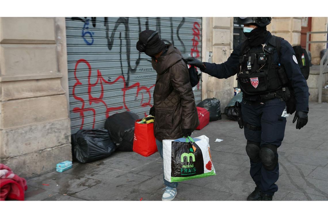 Bilder des Tages Die Polizei räumt ein von Migranten besetztes Theater in Paris: Ein Polizist begleitet einen Mann aus dem Theater La Gaîté Lyrique - einem Aufführungssaal, der drei Monate lang von rund 450 jungen Migranten besetzt war.