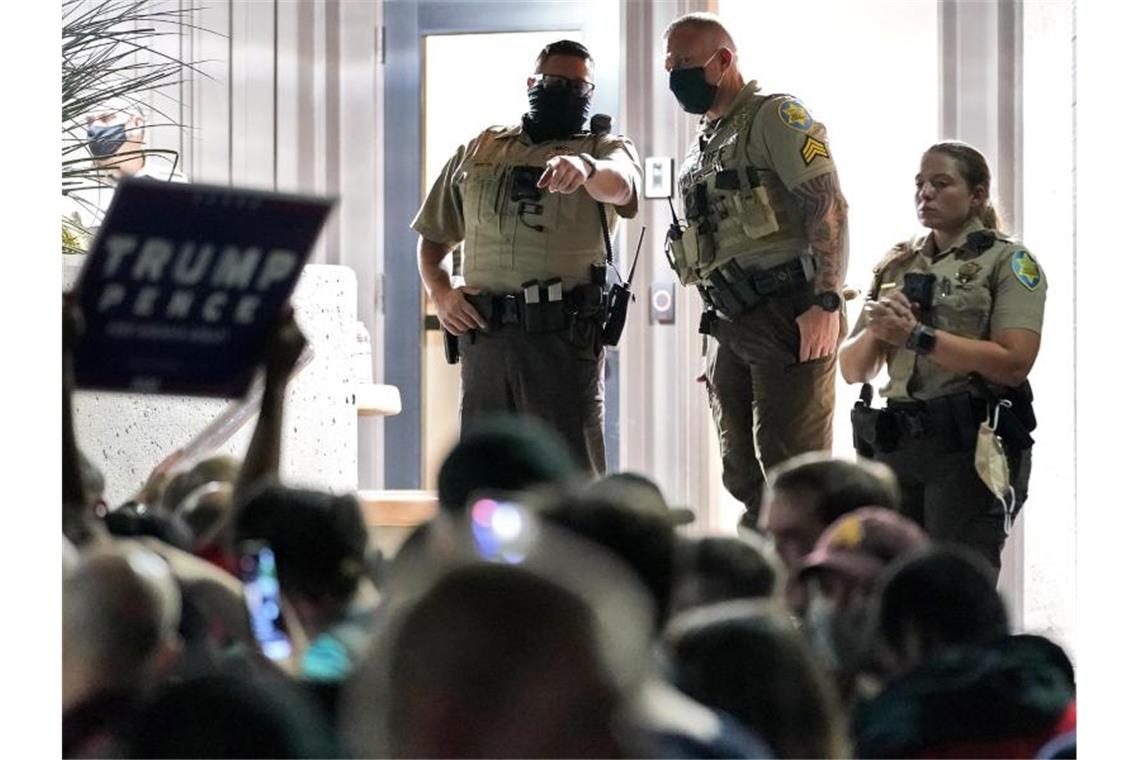 Biden fehlt nur noch ein US-Bundesstaat Die Polizei sichert den Eingang zum Bezirksbüro von Maricopa County in Arizona, wo sich Trump-Anhänger versammelt haben. Foto: Matt York/AP/dpa