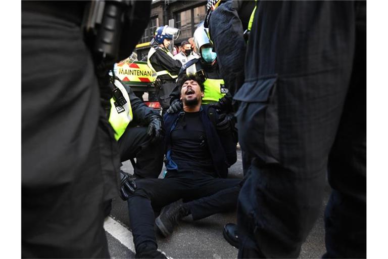 Die Polizei verhaftet einen Demonstranten. Foto: Victoria Jones/PA Wire/dpa