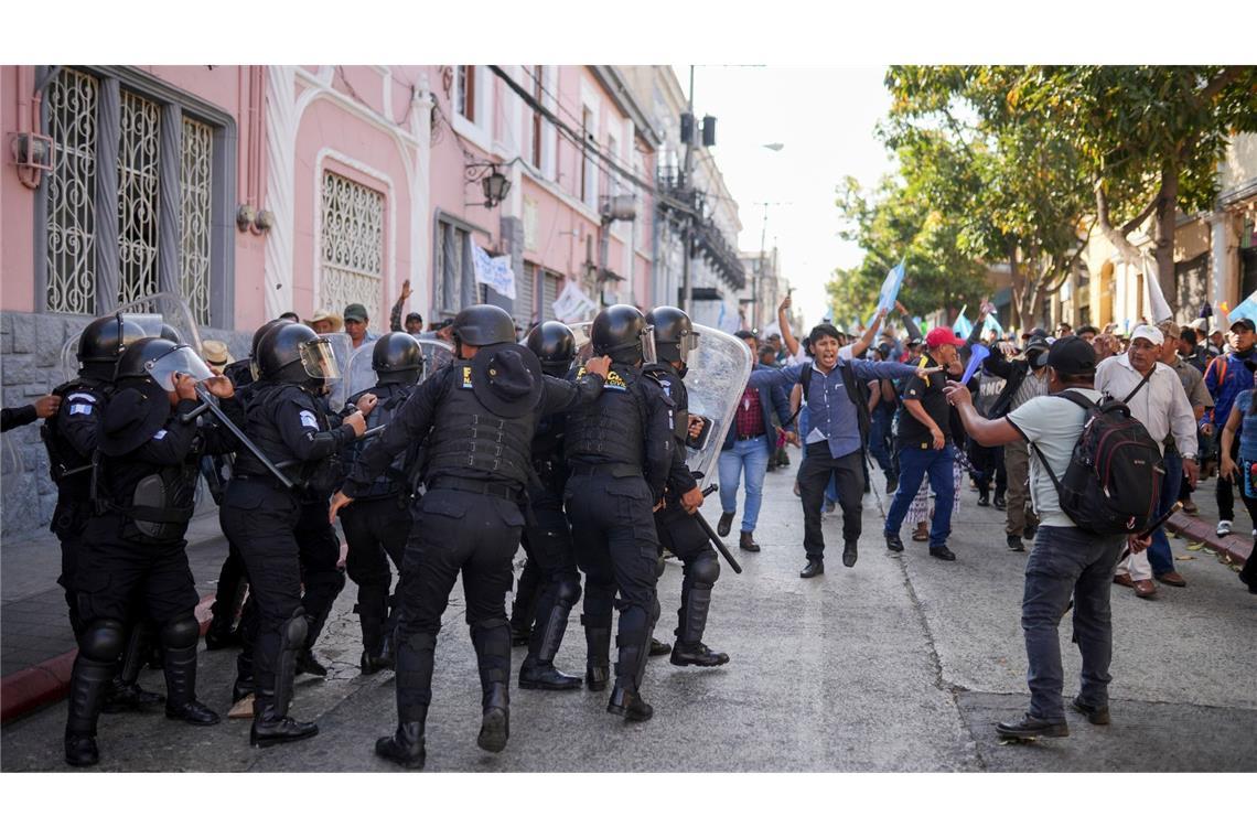 Die Polizei versucht, Anhänger des gewählten guatemaltekischen Präsidenten Arévalo zurückzuhalten, die vor dem Kongress in Guatemala-Stadt gegen eine Verzögerung des Beginns der Legislaturperiode protestieren.