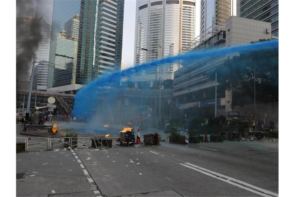 Die Polizei von Hongkong versprüht blau gefärbtes Wasser, um Demonstranten zu markieren. Foto: Vincent Thian/AP/dpa