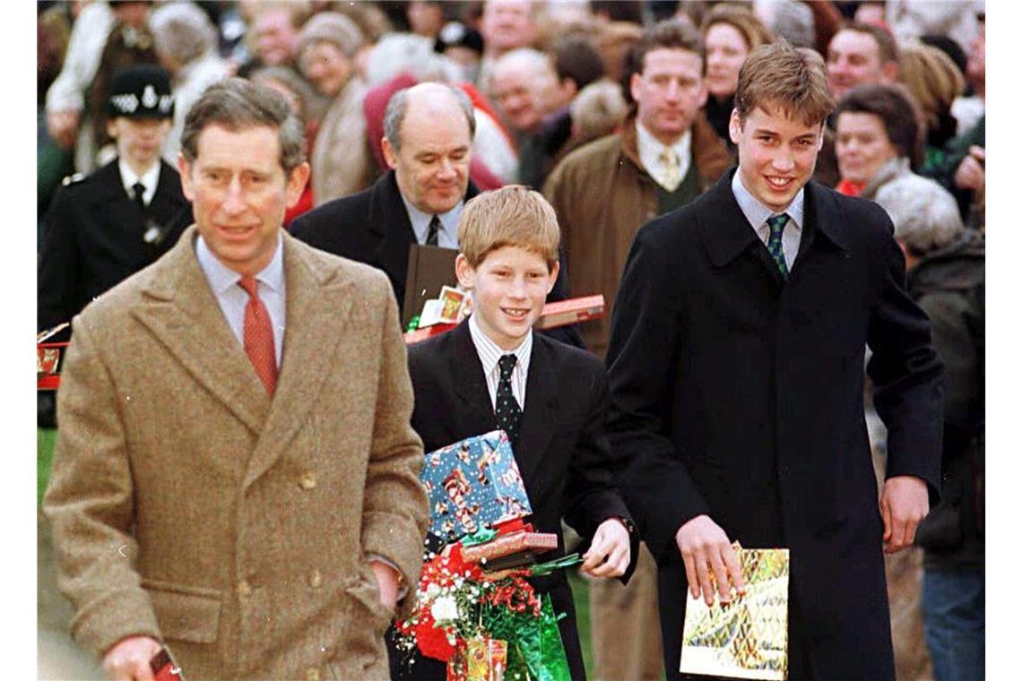 Die Prinzen William (ganz rechts) und Harry halten Geschenke von Gratulanten in den Händen, als sie am 25. Dezember 1997 nach dem Morgengottesdienst gemeinsam mit ihrem Vater, Prinz Charles, die Sandringham-Kirche verlassen. Die beiden jugendlichen Prinzen verbrachten ihr erstes Weihnachtsfest ohne ihre Mutter.