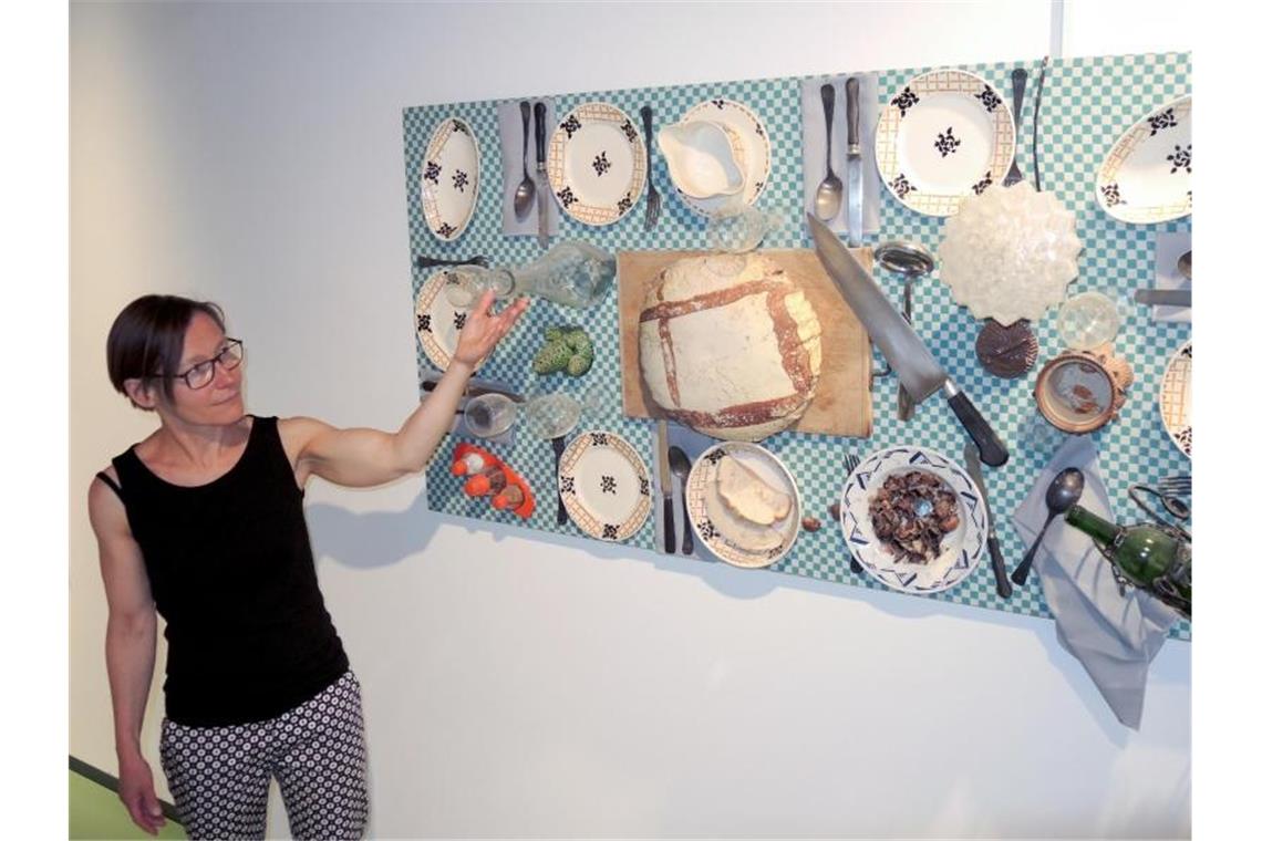 Die Programmverantwortliche des Museums Brot und Kunst, Marianne Honold, zeigt auf ein Werk von Daniel Spoerri. Foto: Thomas Burmeister