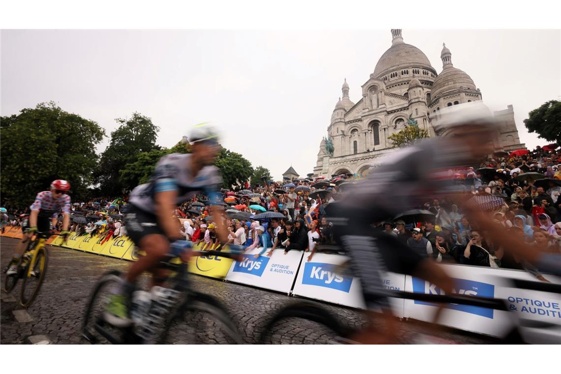 Die Radprofis treten vor der Basilika Sacre Coeur im Stadtteil Montmartre in die Pedale.