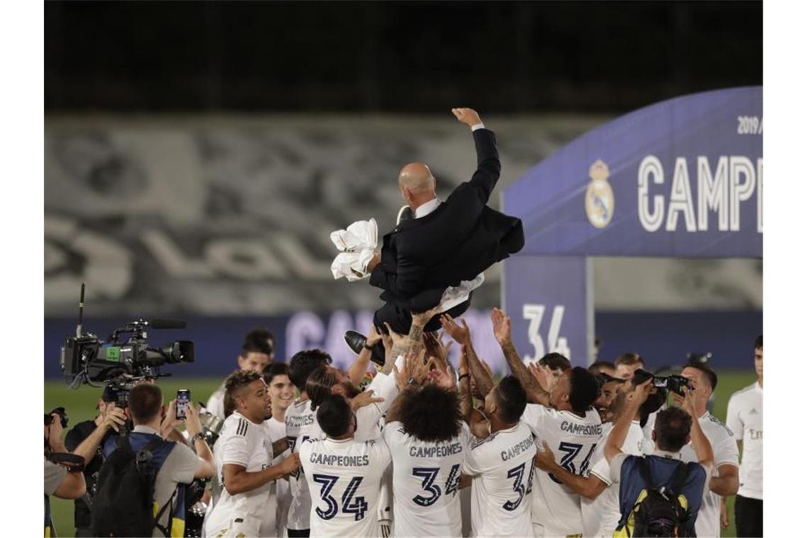 Coup von Real in Corona-Zeiten: Die „Rentner“ wollen mehr Die Real-Profis lassen Meister-Trainer Zinedine Zidane hoch leben. Foto: Bernat Armangue/AP/dpa
