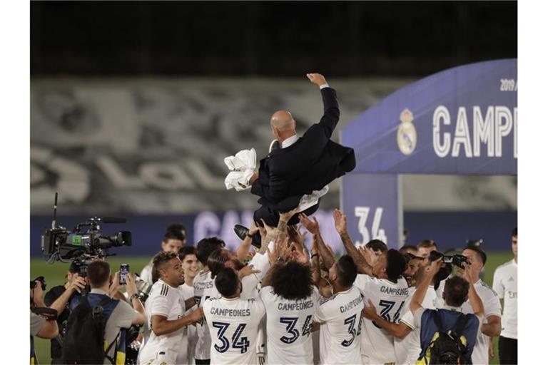 Die Real-Profis lassen Meister-Trainer Zinedine Zidane hoch leben. Foto: Bernat Armangue/AP/dpa
