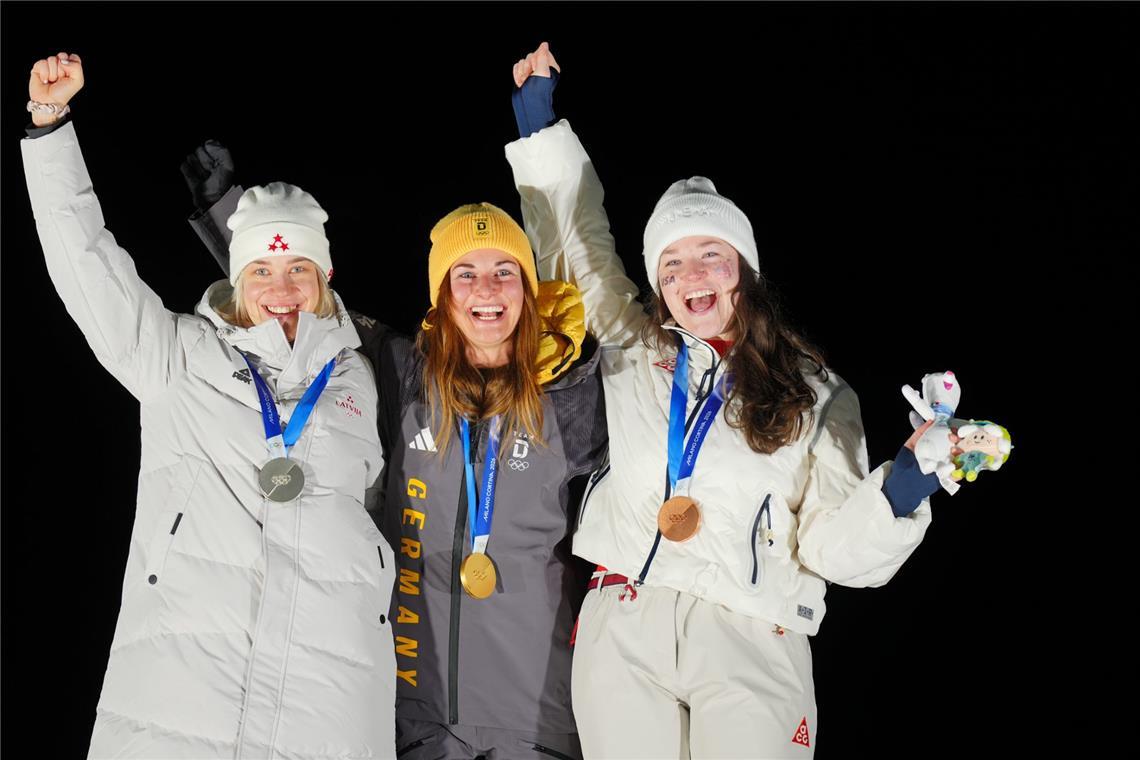Die Rodlerinnen Elina Bota (Lettland, Silber, l-r), Julia Taubitz (Deutschland, Gold) und Ashley Farquharson (USA, Bronze) jubeln bei der Siegerehrung.