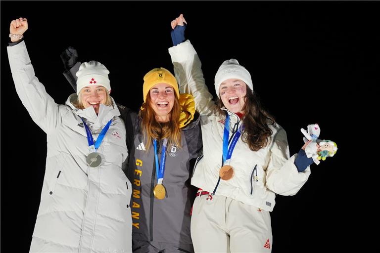Die Rodlerinnen Elina Bota (Lettland, Silber, l-r), Julia Taubitz (Deutschland, Gold) und Ashley Farquharson (USA, Bronze) jubeln bei der Siegerehrung.