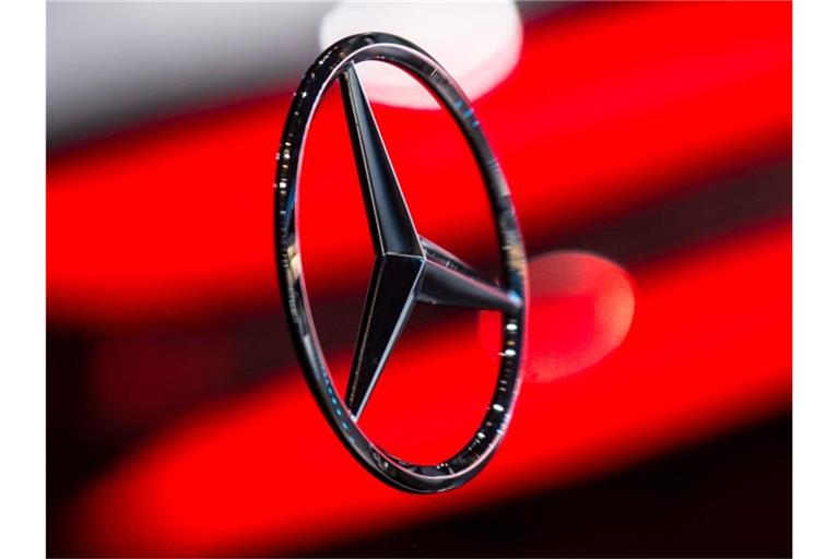 Die Rückleuchte spiegelt sich auf einer Fläche mit dem Mercedes-Logo. Foto: Boris Roessler/dpa/Archivbild