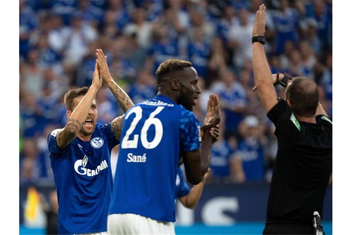 Die Schalker Guido Burgstaller und Salif Sané forderten bei Schiedsrichter Marco Fritz (l-r) ein Handspiel. Foto: Federico Gambarini