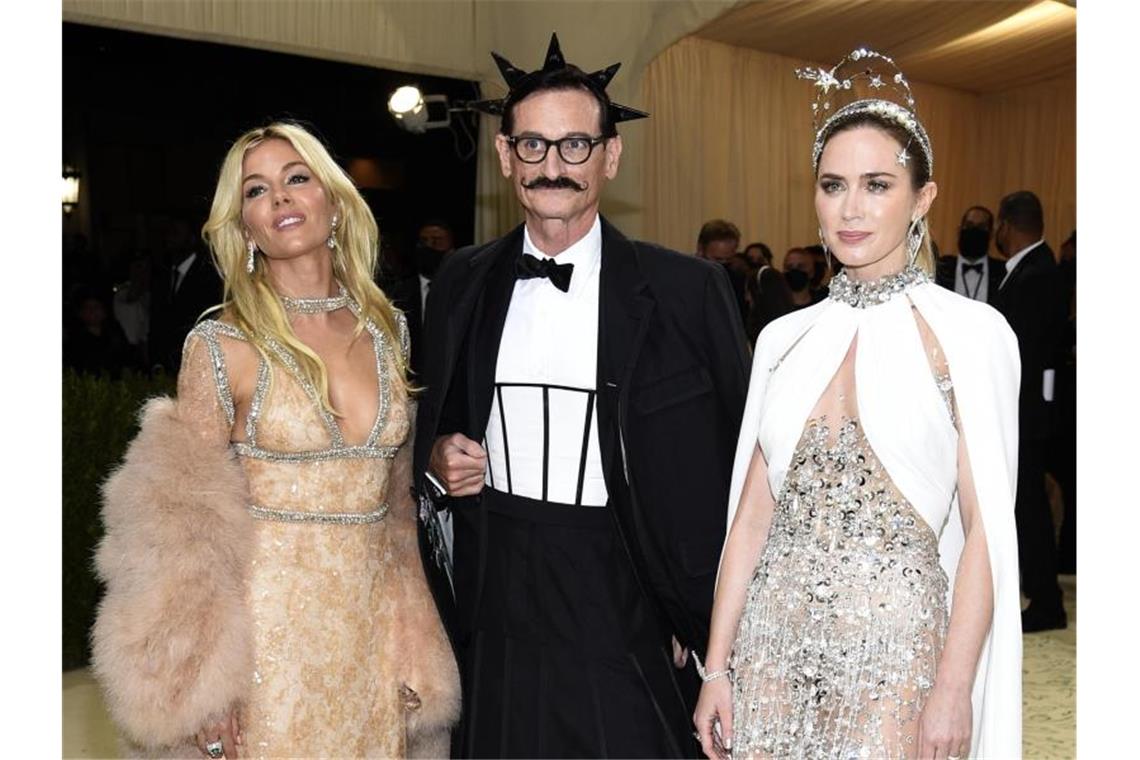 Stars feiern US-Mode bei Met-Gala in New York Die Schauspielerinnen Sienna Miller (l) und Emily Blunt nehmen „Vogue“-Journalist Hamish Bowles in ihre Mitte. Foto: Evan Agostini/Invision via AP/dpa