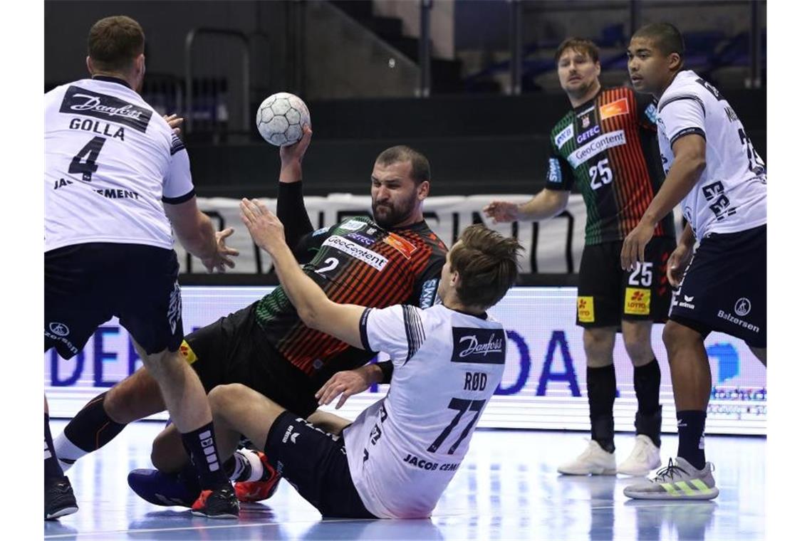 Die SG Flensburg-Handewitt (weiße Trikots) verteidigte in Magdeburg die Tabellenführung in der Handball-Bundesliga. Foto: Ronny Hartmann/dpa