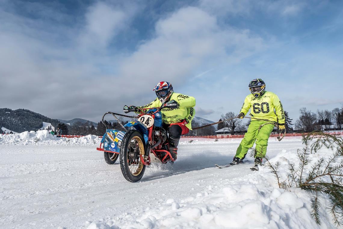 Vorne ein Viertakter, hinten zwei Ski Die Skifahrer müssen beim Skijöring helfen, die Maschinen in der Kurve zu halten.