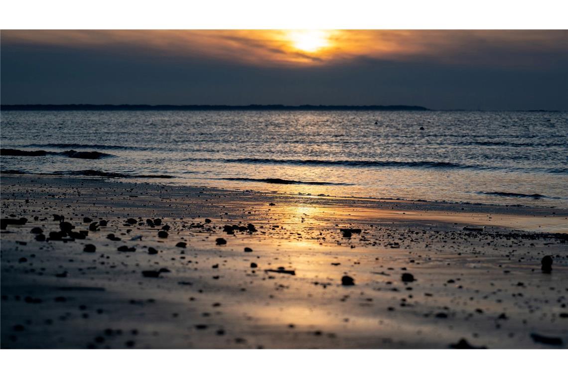 Die Sonne geht am Strand der Insel Langeoog über der Nordsee unter.