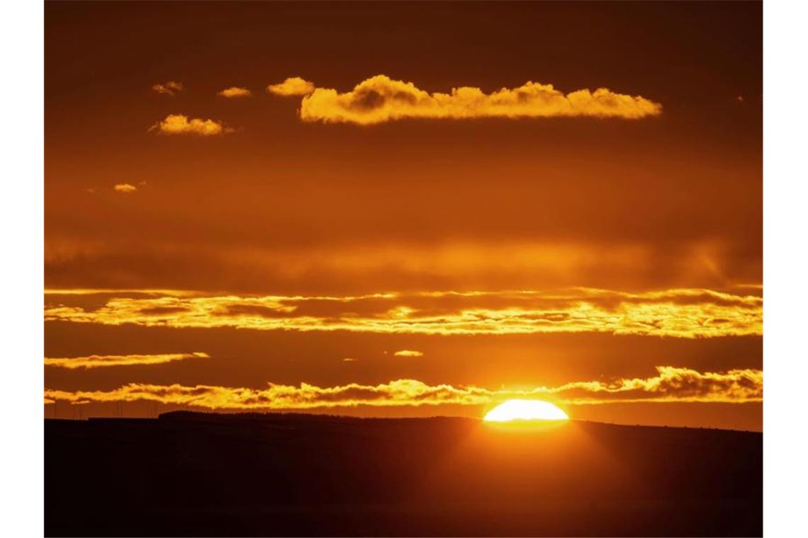 Die Sonne geht auf am Horizont über der Schwäbischen Alb. Foto: Marijan Murat/dpa/Archivbild