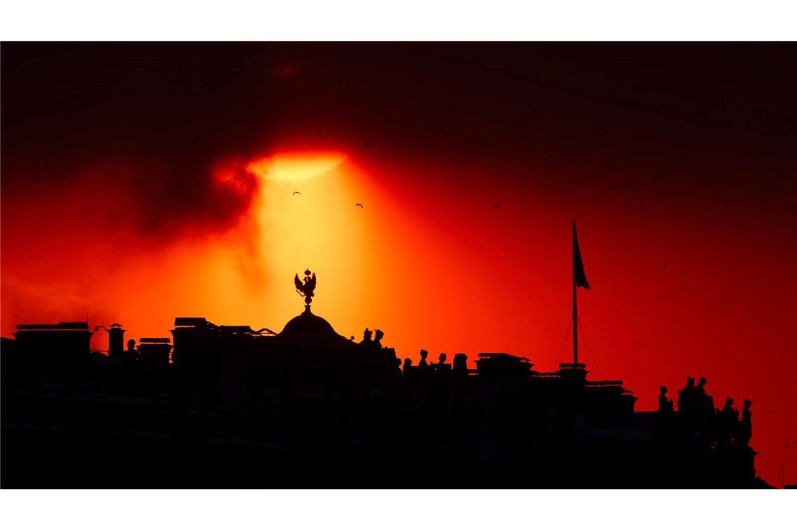Die Sonne geht hinter dem Staatlichen Eremitage-Museum in St. Petersburg unter.