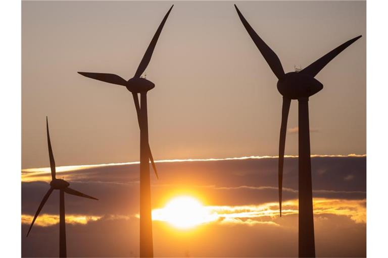 Die Sonne geht hinter Windkraftanlagen unter. Foto: Klaus-Dietmar Gabbert/zb/dpa