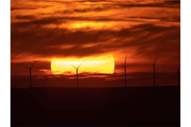 Die Sonne geht über Windrädern auf. Foto: Sebastian Gollnow/dpa