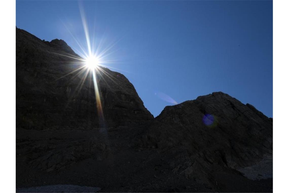 Die Sonne kommt am Morgen hinter einem Felsen im Watzmannkar (Bayern) hervor. Foto: Angelika Warmuth/dpa
