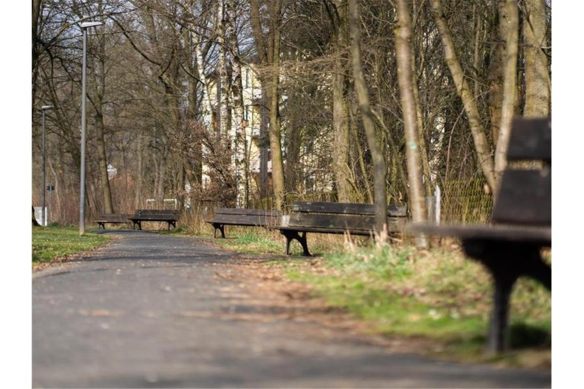 Wärmster Märztag seit Beginn regelmäßiger Aufzeichnungen Die Sonne scheint auf leere Sitzbänke entlang eines Fußgängerweges. Foto: Nicolas Armer/dpa/Symbolbild