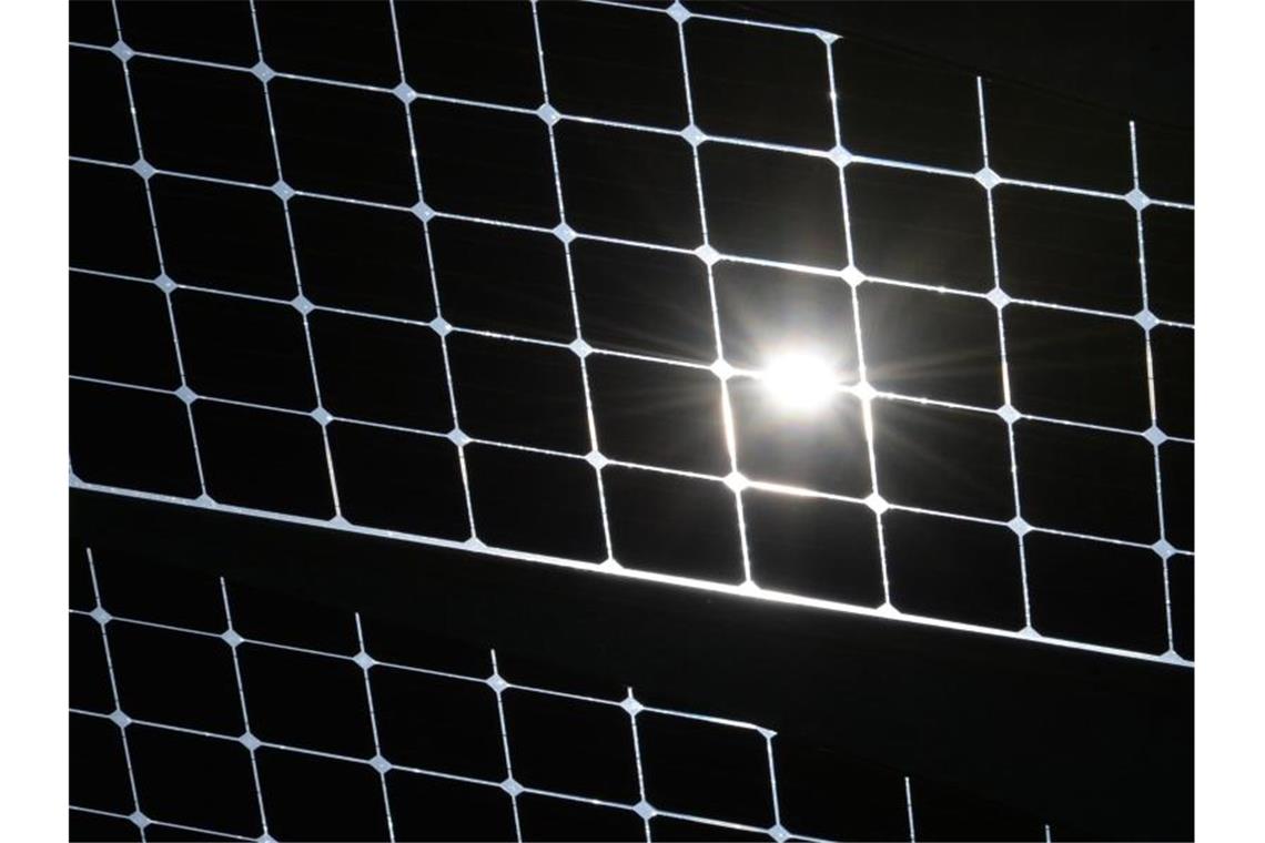 Die Sonne scheint durch die Solarzellen einer Solaranlage. Foto: Patrick Seeger/dpa/Archiv