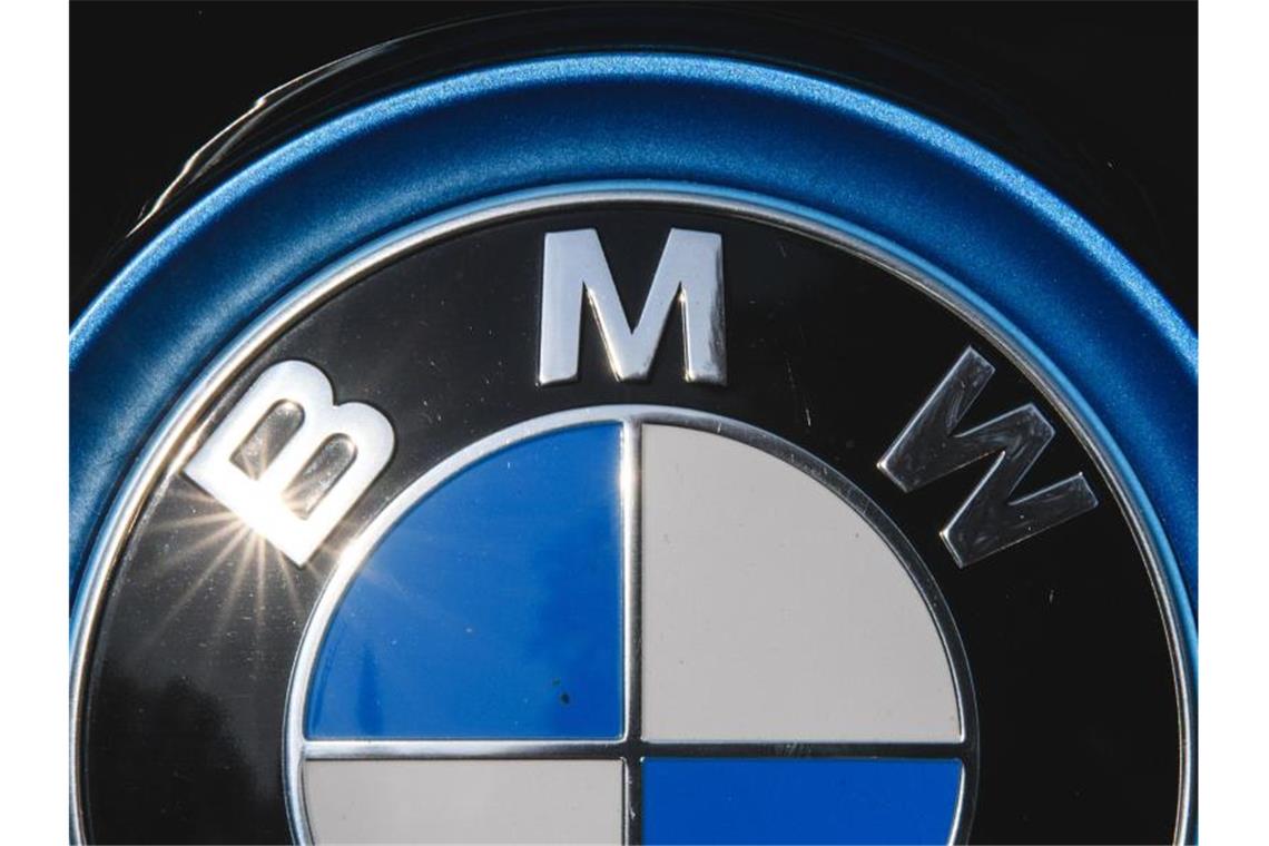 Die Sonne spiegelt sich in einem Logo des Autoherstellers BMW. Foto: Sebastian Gollnow/dpa/Archivbild